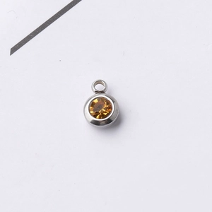 Detail of a 6.5mm silver stainless steel pendant with an amber round birthstone