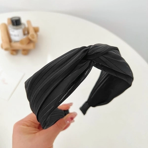 Details eines eleganten schwarzen Stoffstirnbands mit modischem Knotendesign