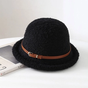Détail du chapeau bob en peluche noire avec sangle en cuir marron et texture douce