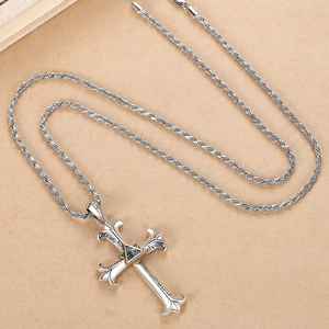 Hip hop silver cross necklace with golden Eye of Providence on beige paper background