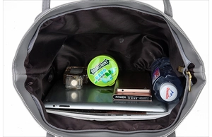 Top view showing internal capacity of the gray soft leather tote with various daily essentials
