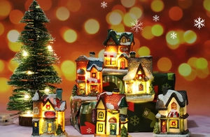 Macro detail of LED Christmas resin house with warm glow and colorful painted texture