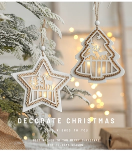Close-up of glowing wooden star and tree ornaments with LED lights on a snowy branch