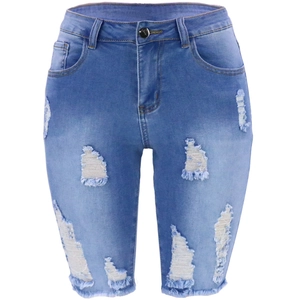 Gros plan détaillé de short en jean déchiré montrant les trous et la texture du coton