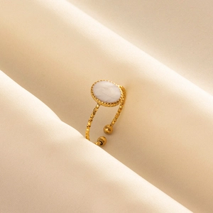 Detailed macro view of an adjustable gold ring featuring an oval white textured stone