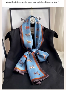 Detailed view of a blue silk scarf with colorful horse print and dark brown rolled edges