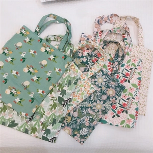Détail de mini sacs en toile à fleurs avec boutons pression en plusieurs coloris