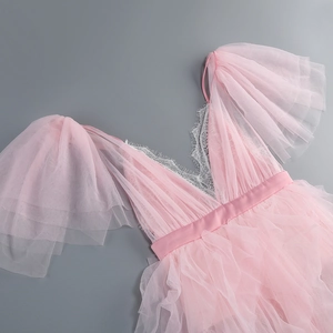 Detail of pink mesh dress featuring delicate lace V-neckline and tiered ruffle sleeves