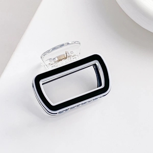 Détail d'une pince à cheveux rectangulaire noir et blanc avec levier transparent