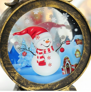 Detail of Christmas lantern with bronze frame showing snowy snowman scene and rustic texture