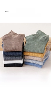 Macro shot of assorted multi-color cotton ankle socks featuring ribbed cuffs and soft texture