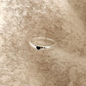 Detail of S925 sterling silver open ring featuring a minimalist black heart on plush fabric