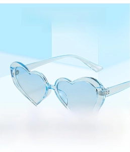 Detail of light blue heart-shaped sunglasses with a transparent fashion plastic frame