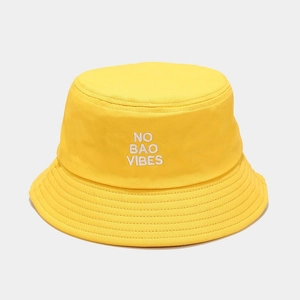 Close-up of bright yellow cotton bucket hat with white NO BAO VIBES embroidery detail