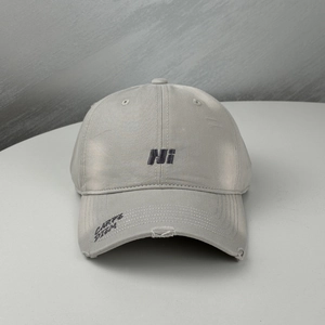 Close-up of distressed baseball cap with HI embroidery and Carpe Diem text on brim
