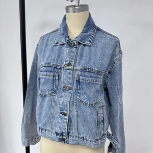 Vue détaillée avant d'une veste en jean bleu clair avec boutons en métal et poches poitrine