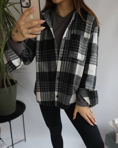 Mirror selfie showing the detail of a black and white plaid flannel shirt with front pockets