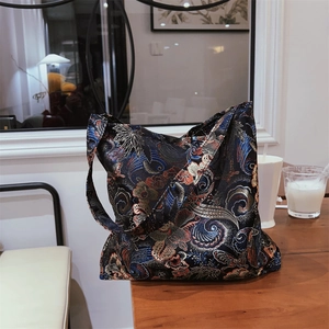 Macro shot of a vintage Chinese brocade tote bag featuring intricate floral and phoenix patterns