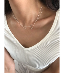 Close-up of double-layered S925 silver necklace with H letter pendant on a model's neck