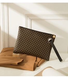 Detailed view of crocodile pattern briefcase with brown geometric texture and black strap