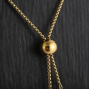 Detailed macro shot of a gold titanium adjustable necklace with sliding bead closure
