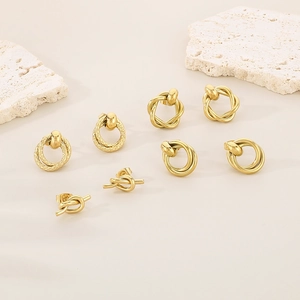 Close-up of assorted gold interlocking double hoop earrings and minimalist twisted studs