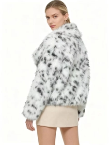 Detailed texture of black and white spotted faux fur on a cozy winter short coat