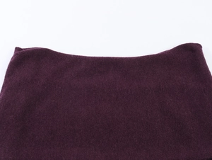 Gros plan sur le tissu en tricot violet foncé montrant la texture douce et le col