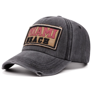 Close-up of vintage washed grey cotton baseball cap with MIAMI BEACH patch and frayed edges