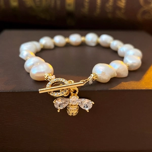 Close-up of baroque pearl bracelet with sparkling zircon bee charm and T-bar toggle clasp