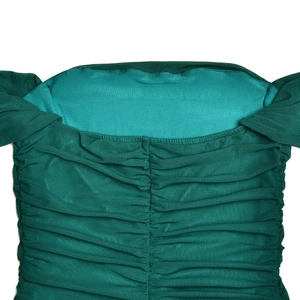Close-up detail of dark green mesh dress featuring horizontal pleats and off-shoulder neckline