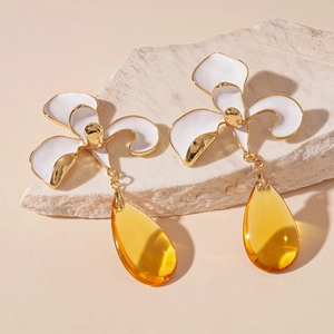 Detail of vintage iris flower earrings with amber teardrop glass and gold-edged petals