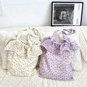 Gros plan de sacs fourre-tout en mousseline fleurie avec volants crème et lavande