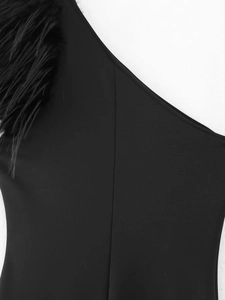 Dettaglio dell'abito nero con piume di struzzo eleganti sulla spalla singola