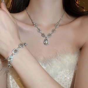 Silver teardrop jewelry set with necklace and bracelet featuring sparkling rhinestones