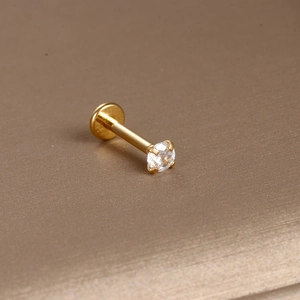 Macro shot of gold-plated stainless steel labret stud with a clear zircon stone setting
