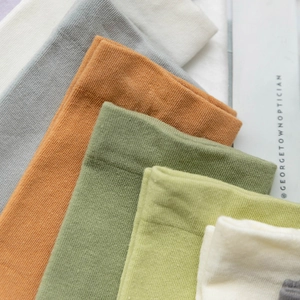 Set of colorful ribbed cotton socks in Morandi tones shown in a layered diagonal pile