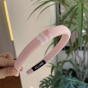 Pink fabric headband featuring white lace edges and button details for women