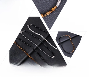 Détail du collier de perles en oeil de tigre et obsidienne avec fermoir OT argenté