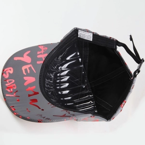 Close-up of reflective baseball cap interior showing 100% cotton label and red brim print