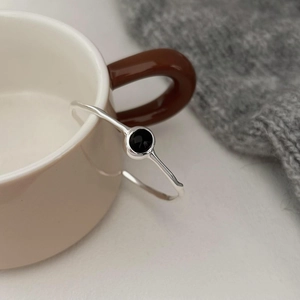 Detailed shot of S925 sterling silver geometric ring with black onyx on ceramic cup