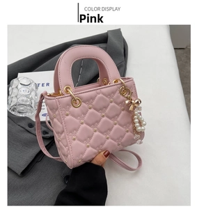 Detailed close-up of a pink quilted mini bag with gold studs and a pearl bow charm