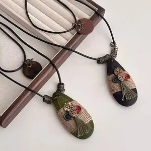 Detail of ethnic long necklaces with wooden pendants, tassels and retro buttons