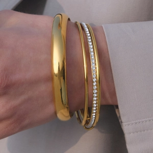 Ensemble de trois bracelets joncs empilables en acier plaqué or 18k sur un mannequin