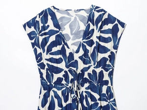 Detail von Sommerkleid mit V-Ausschnitt, blauem Blattmuster und Kordelzug an der Taille