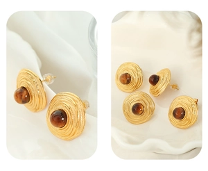 Detailed macro view of vintage gold stud earrings with radial texture and tiger eye stone