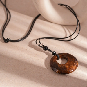 Detailed view of vintage amber resin hollow round pendant on adjustable long necklace