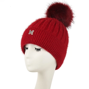 Détail du bonnet en maille avec pompon en peluche et lettre M en strass brillant