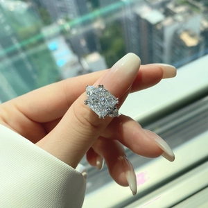 Detailed view of square cut 8A zircon ring on finger with elegant three-stone design