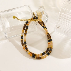 Macro view of brown tiger eye beads and golden stainless steel lobster clasp